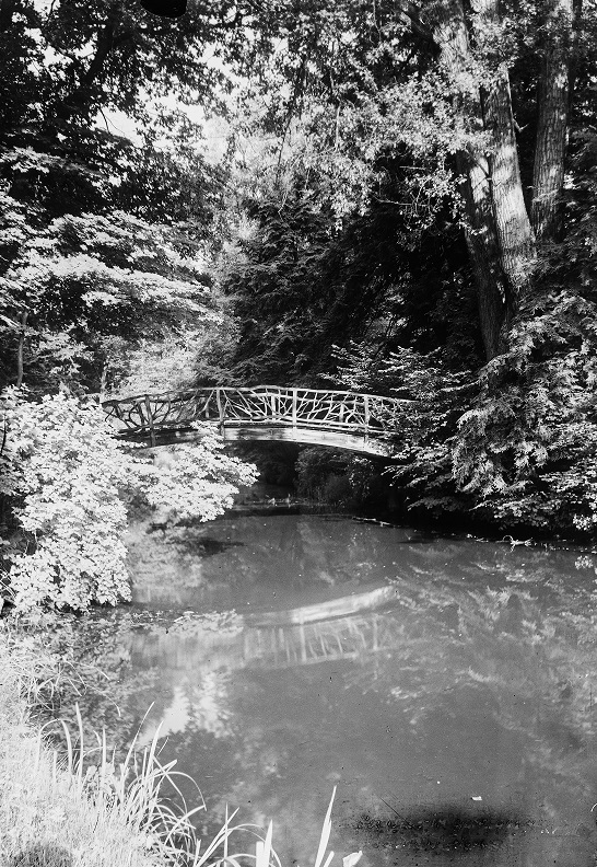 Drewniany most w parku. Fotografia z latach 30. XX wieku autorstwa Michała Święcha