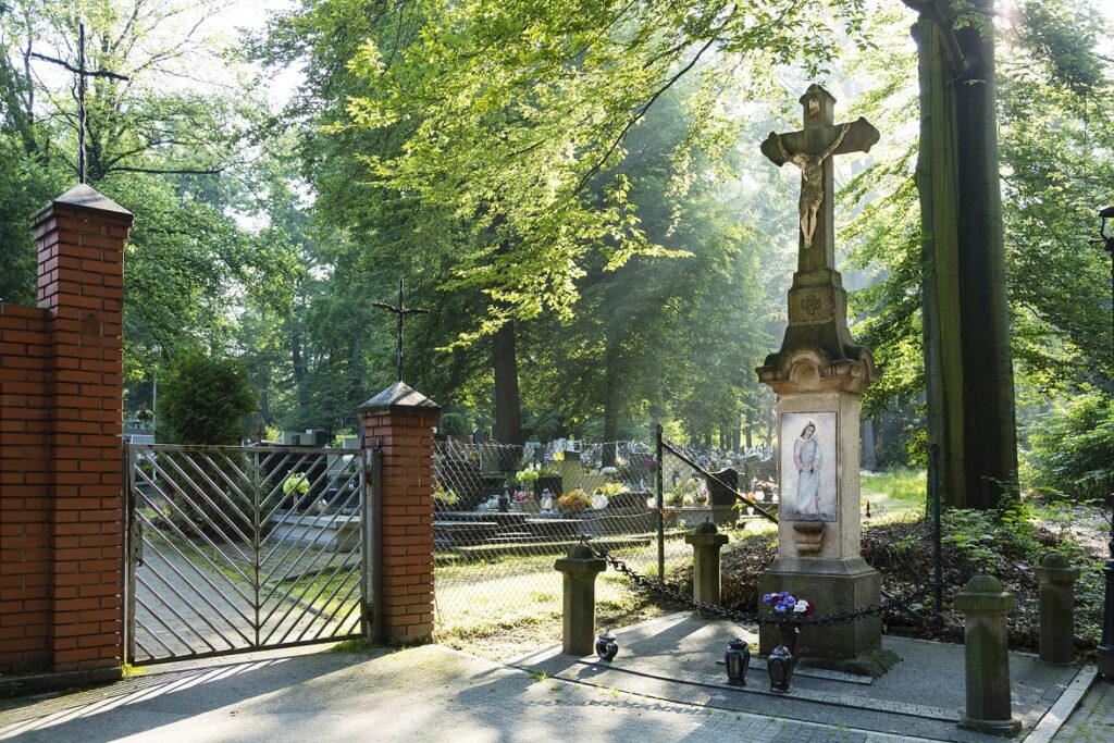 Kamienny krzyż przy bramie cmentarnej fotografia współczesna